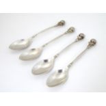 A matched set of 4 silver teaspoons with acanthus decoration to bowl and handles surmounted by golf