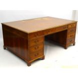 A mid 20thC mahogany partners desk with tooled leather inset top,