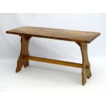 A late 20thC burr yew kitchen table with trestle base. Stamped "Reynolds of Ludlow".