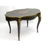 A late 19thC ebonised centre table with gilt mounted rim and caryatids to the legs,