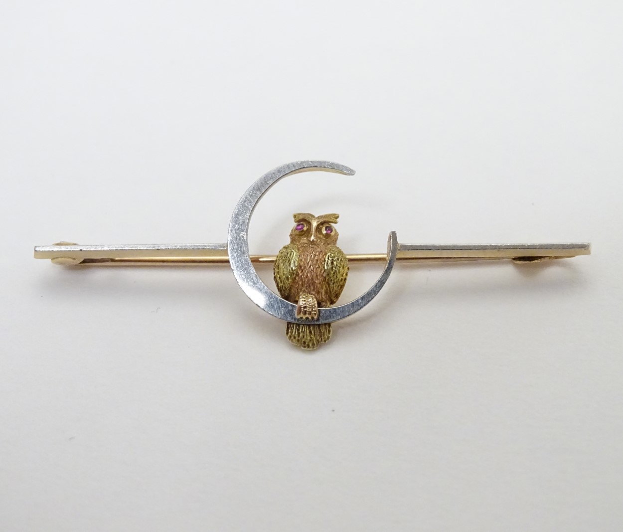 A 15ct gold and platinum bar brooch with owl and moon decoration 2" wide CONDITION: