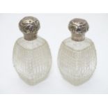 A pair of cut glass dressing table perfume / scent bottles with silver tops hallmarked London 1891