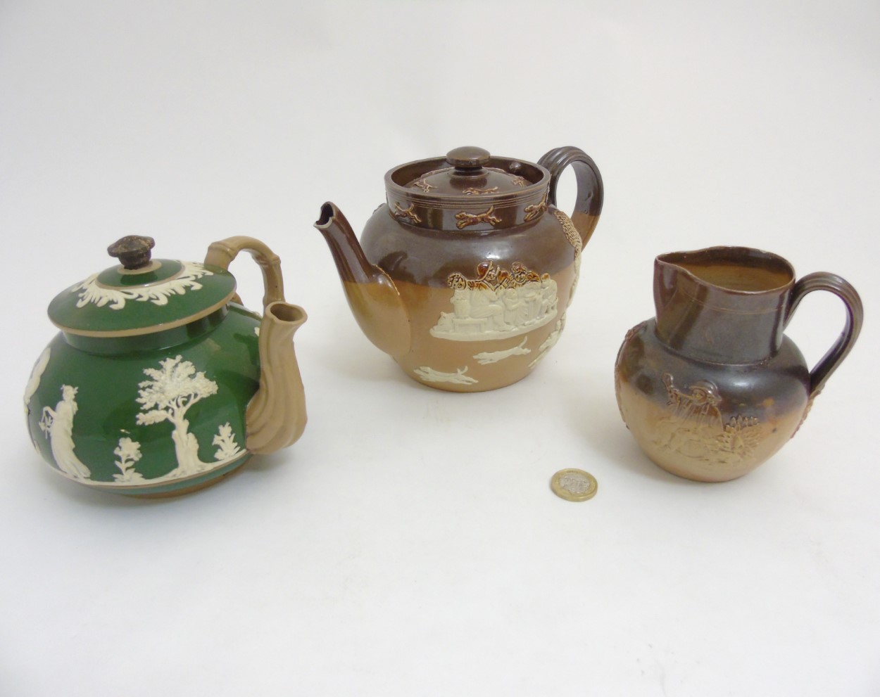 Three pieces of stoneware ceramics comprising a Royal Doulton salt glazed hunting teapot,