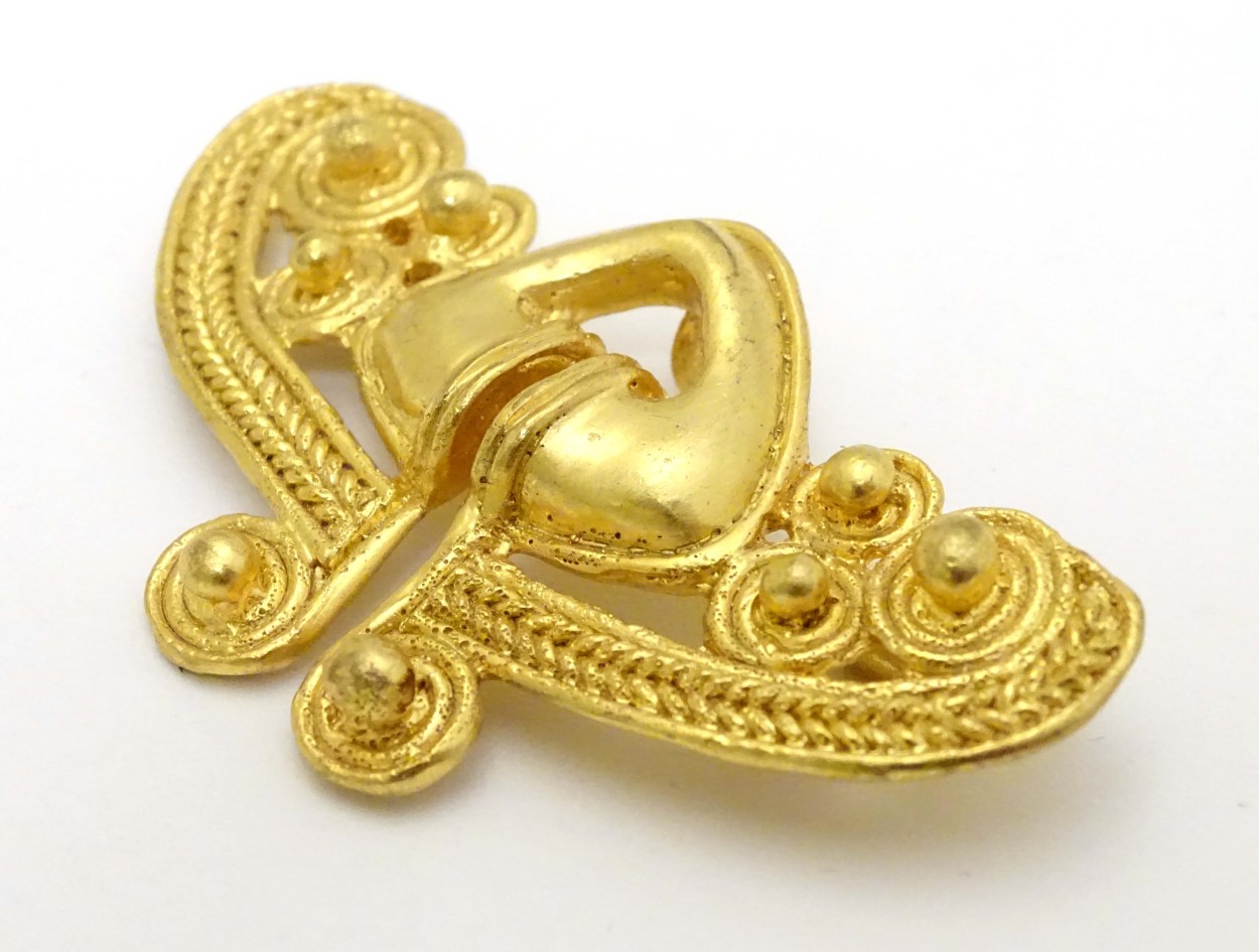 A gilt brooch of abstract form marked to reverse REU.