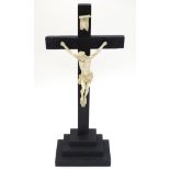 Crucifix : a Christian ebonised cross with corpus on a stepped base with a white resin Christ ,