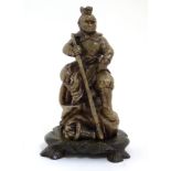 Japanese Soapstone Figure : a carved figure holding a staff and seated on a rock ,