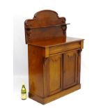 A Victorian mahogany chiffonier having a shaped back with display shelf under,