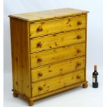 An early 21stC pine chest of drawers comprising five long drawers with turned knob handles and