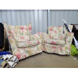 A pair of his and hers armchairs with floral upholstered covers,