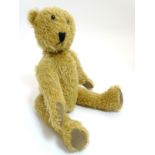 An early/mid 20thC mohair teddy bear with articulated joints, long arms, black button eyes,