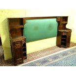 An Edwardian mahogany bedhead with concave night stands to each end, to include a drawer,