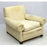 A late Victorian upholstered and overstuffed armchair with walnut bun feet.