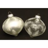 Christmas decorations : two glass baubles one clear glass the other white.