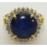 A 14k gold ring set with central blue cabochon bordered by diamonds CONDITION: