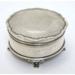 A silver ring box of circular form with engine turned decoration to hinged lid and standing on four