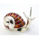 A white metal model of a snail with enamel decoration to shell.