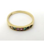 A 9ct gold ring set with band of coloured stones including diamond emerald etc.
