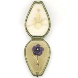 A late 19thC / early 20thC yellow metal brooch formed as a flower with purple guilloche enamel