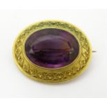 A Victorian yellow metal brooch set with large amethyst.