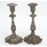 A pair of silver plate candlesticks with profuse fruiting vine decoration.