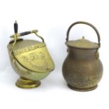 A pot-bellied brass coal scuttle and lid with lions mask handles together with another brass coal