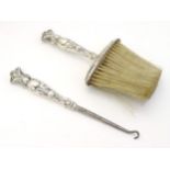 An American Sterling silver handled hat brush and shoe horn with peacock and Art Nouveau decoration.