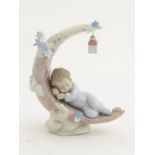 A Lladro figure of a baby boy asleep on the moon, 'Heavenly Slumber', no. 6479, approx. 7" high.