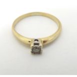 A 9ct gold ring set with diamond solitaire in a squared setting CONDITION: Please
