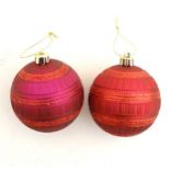 Christmas decoration : two red / burgundy spherical baubles .