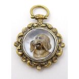 A gilt metal pendant having central Essex Crystal cabochon depicting the head of a Spaniel like dog.