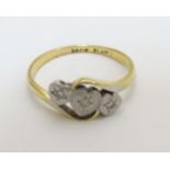 An 18ct gold ring set with three diamonds in a platinum heart shaped setting CONDITION: