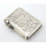 A silver vesta case with engraved acanthus scroll decoration.