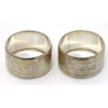 A pair of Victorian silver napkin rings with engraved decoration hallmarked Birmingham 1875 maker