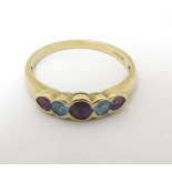 A 9ct gold ring set with amethysts and aquamarine in a linear setting CONDITION: