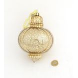 Christmas decoration : A large glass gold coloured bauble with banded decoration .