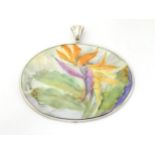An oval ceramic pendant having hand painted decoration by Mary Belle Cordell,