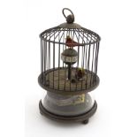 Automaton : a novelty clockwork brass birdcage clock with glazed section under showing workings ,