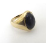A 9ct gold ring set with dark stone cabochon,