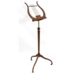 A late 19thC / early 20thC mahogany lyre shaped music stand with marquetry inlay and canted
