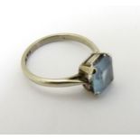 A 9ct white gold ring set with aquamarine, and having a 9ct gold size adjuster.