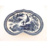 An oriental blue and white kidney shaped dish decorated with oriental scenes of fishing, pagodas,