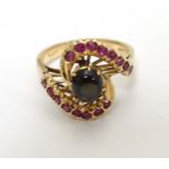 An 18ct gold ring set with spinel cabochon boarded by red stones.