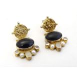 A pair of gilt white metal drop earrings set with dark stone cabochon, pearls and moonstones.