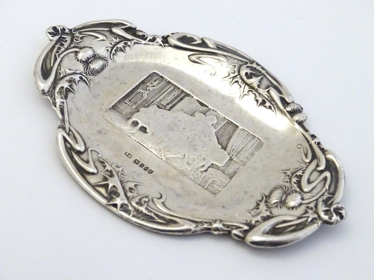 A silver pin dish with thistle decoration to border and interior scene to centre. - Image 3 of 5