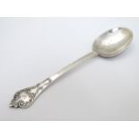 A silver Christening spoon with scroll decoration.