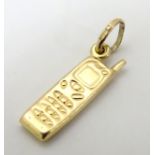 A yellow metal charm / pendant formed as an early mobile phone ¾” long CONDITION: