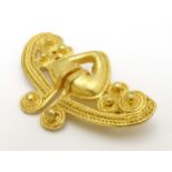 A gilt brooch of abstract form marked to reverse REU.
