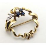 A 9ct gold brooch set with sapphires and diamonds.