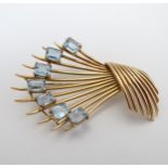 A yellow metal brooch of abstract form set with 7 aquamarines 2 1/2" long CONDITION: