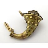 A gilt metal pendant formed as a flowering cornucopia 1” long CONDITION: Please